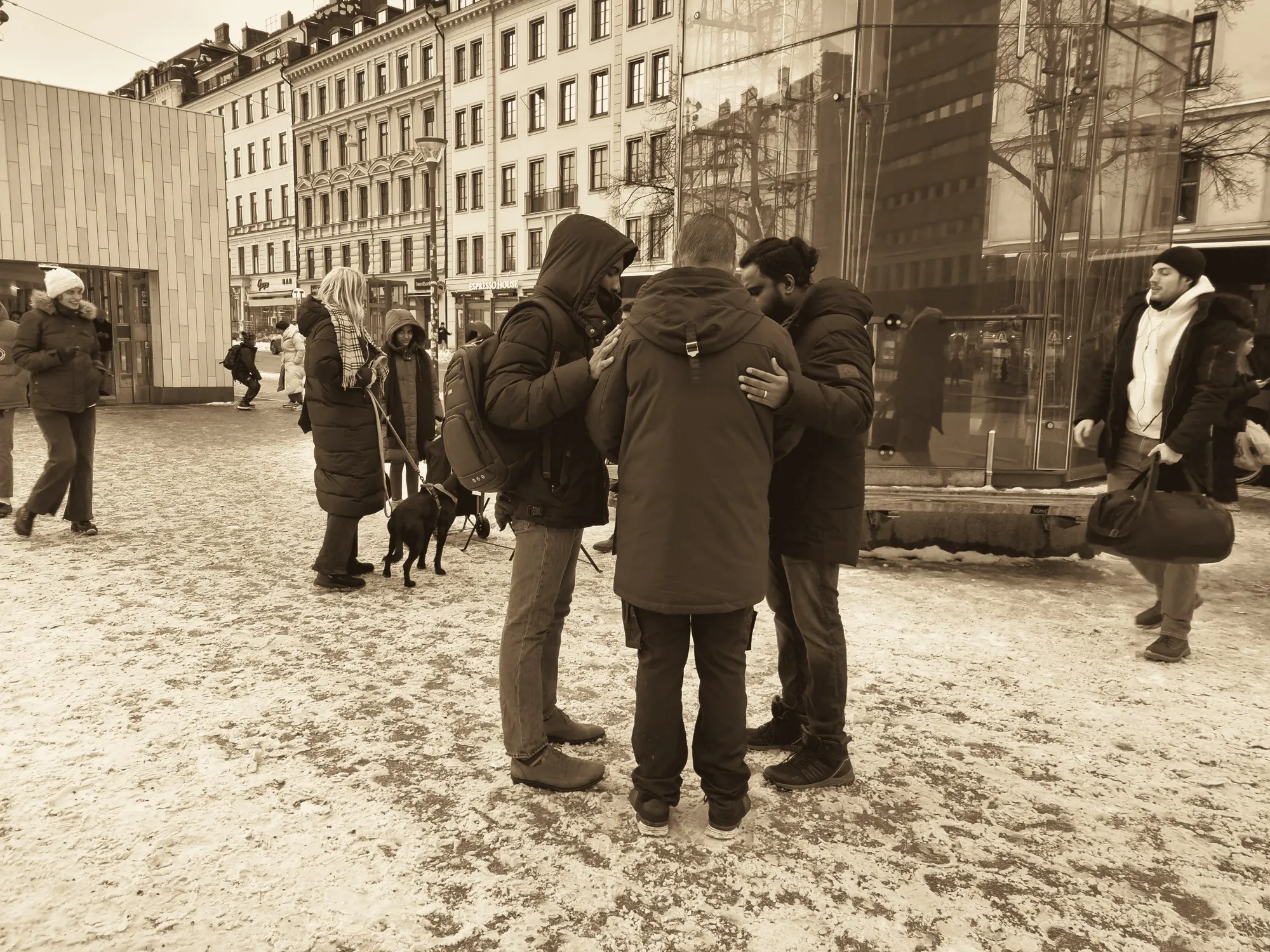 Church members praying together on a snowy square in Stockholm