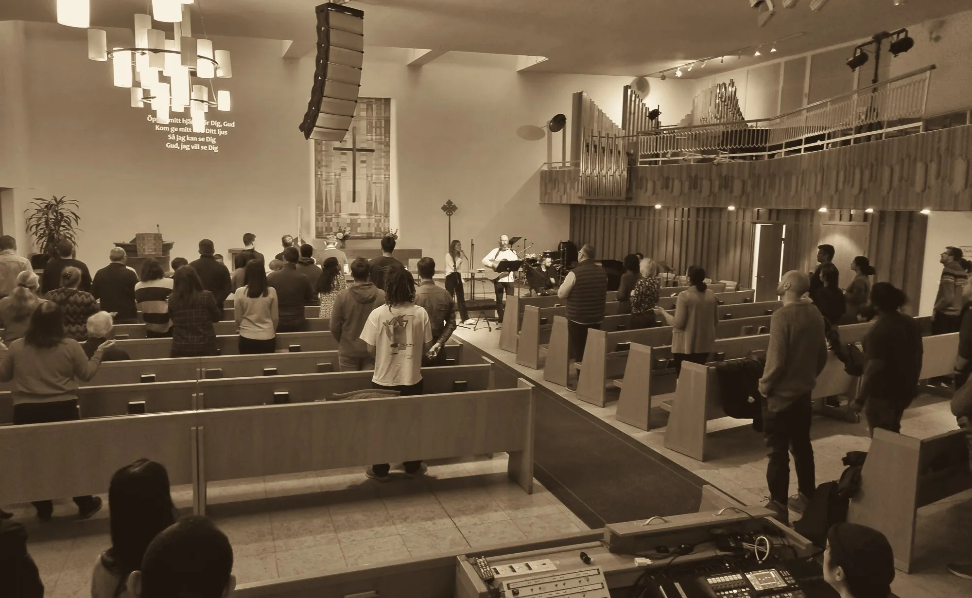The congregation standing in worship during a Sunday service at Betlehemskyrkan