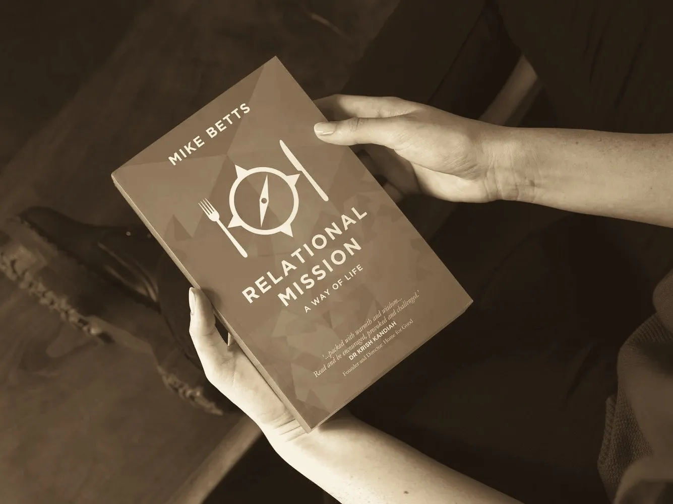 Hands holding the book Relational Mission: A Way of Life